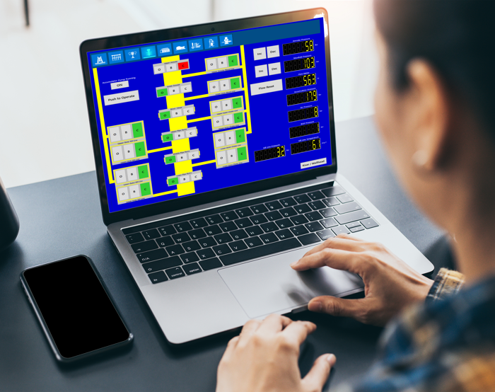 A person uses a laptop displaying a complex blue and yellow flowchart.