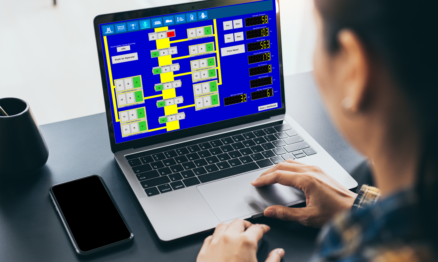 Une personne utilise un ordinateur portable affichant un organigramme complexe bleu et jaune.