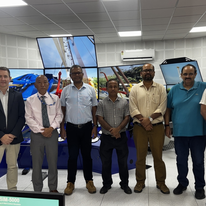 ocho hombres de pie frente a grandes pantallas de simulador